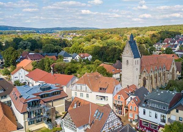 Ansicht einer Kirche im Ortskern aus der Vogelperspektive bei Tag und blauem Himmel im Sommer