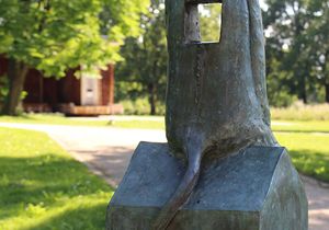 Abbildung der Rückseite einer Skulptur im Grünen bei sommerlichem Wetter