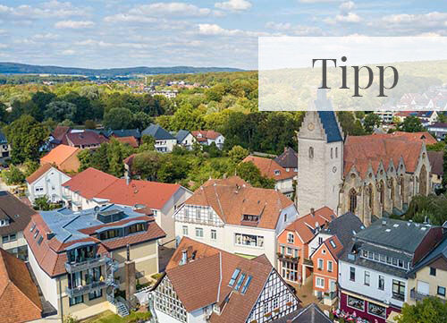 Ansicht einer Kirche im Ortskern aus der Vogelperspektive bei Tag und blauem Himmel im Sommer