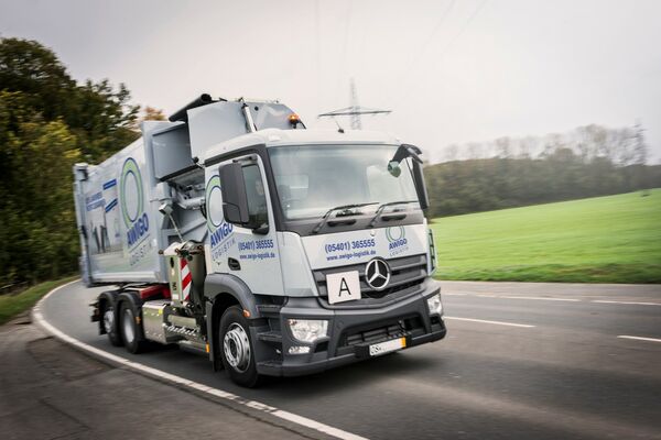 gruaer Müllwagen fährt eine Straße entlang