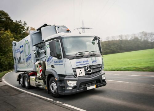 gruaer Müllwagen fährt eine Straße entlang