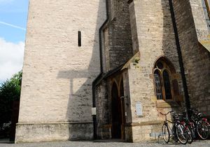 Kircheneingang und ein voller Fahrradständer vor der Kirche