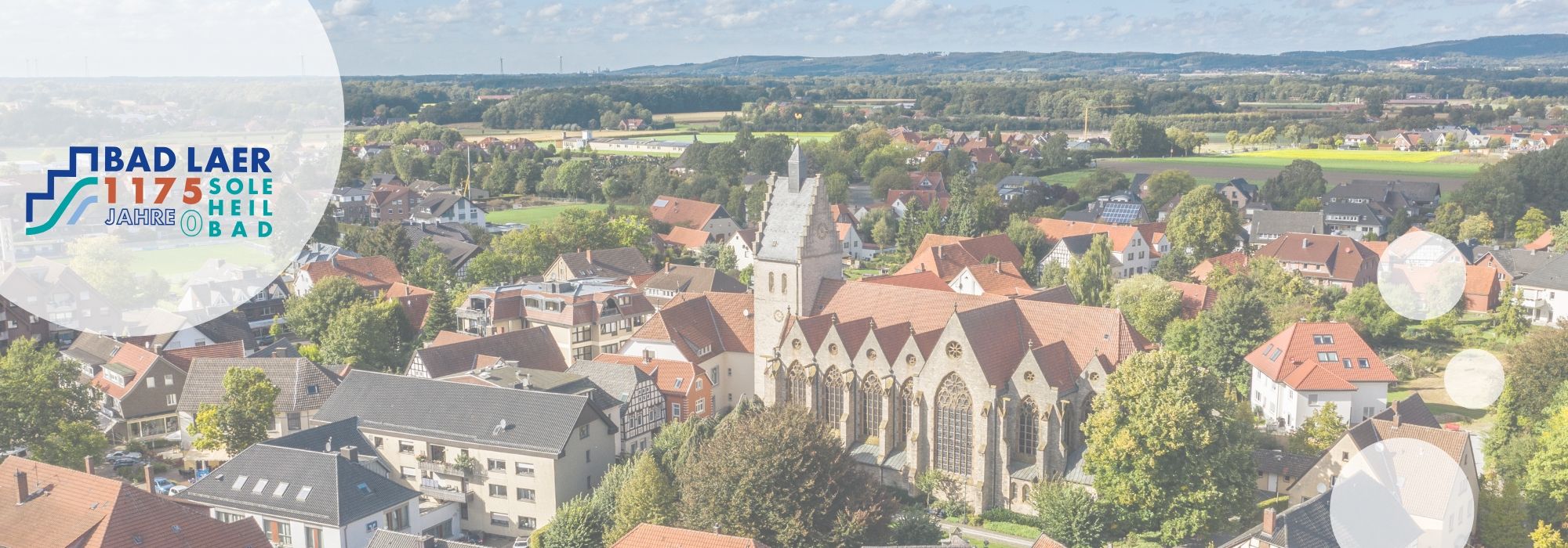 Ortskern von Bad Laer mit katholischer Kirche von oben mit Jubiläumslogo