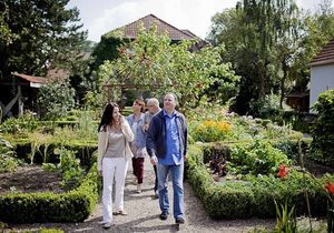 Zwei Männer und zwei Frauen spazieren durch einen Garten