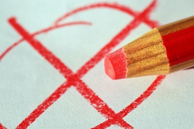 Wahlkreuz Ein roter Kreis, der angekreuzt ist und daneben liegt ein roter Stift