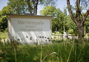 Kleines Häuschen der Martinsquelle im Grünen bei sommerlichem Wetter