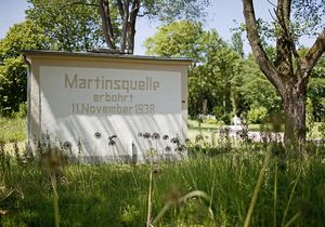 Kleines Häuschen der Martinsquelle im Grünen bei sommerlichem Wetter