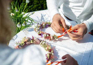 Blumenkränze binden auf dem Mittsommer-Markt in Bad Laer