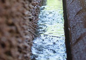 Nahaufnahme der Wasserrinne eines Gradierwerkes am Tag