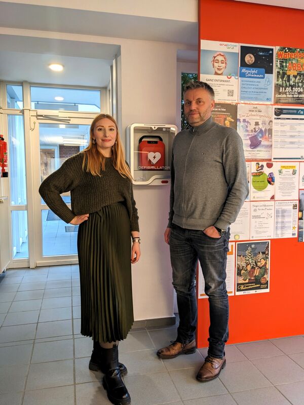 Nina Strickmann und Jens Giesker vor dem neuen Defibrillator der Bad Laer Touristik GmbH