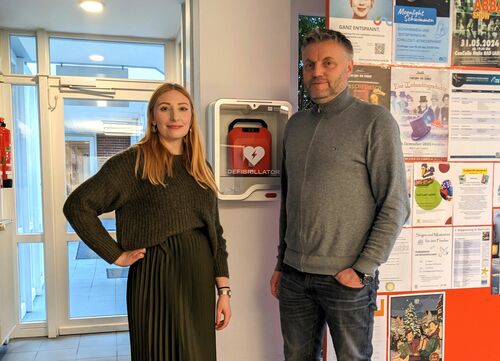 Nina Strickmann und Jens Giesker vor dem neuen Defibrillator der Bad Laer Touristik GmbH