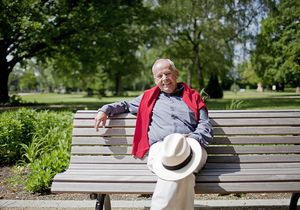 Ein Mann sitzt im Frühling auf einer Bank im Park