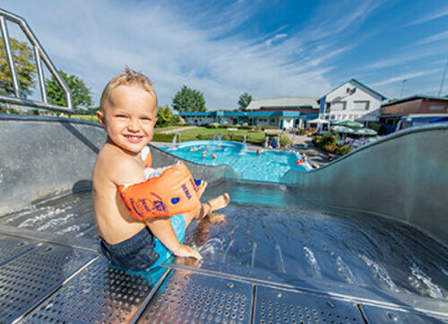 Kind auf Rutsche im Freibad