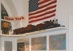 Themenbereich New York mit verschiedenen Karten, Ausstellungsstücken und einer Fahne