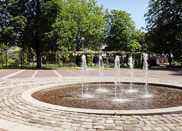 Springbrunnen auf einem Platz im Ort bei sommerlichem Wetter