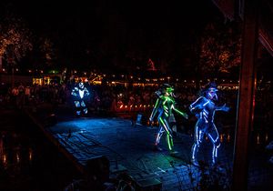 Eine Show mit Künstlern, die leuchtende Kostüme haben