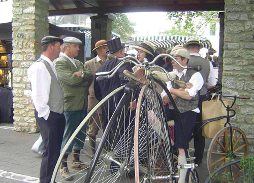 Menschen mit Hüten und alten Fahrrädern im Freien